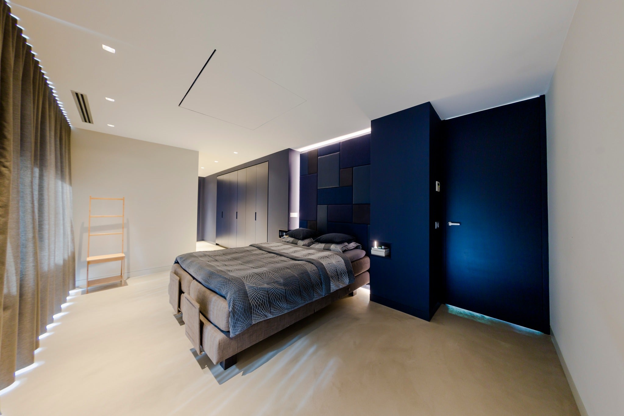 Soverom med lys grå basebeton mikrosementgulv og blå mikrobetong på veggene – moderne og rolig innredning